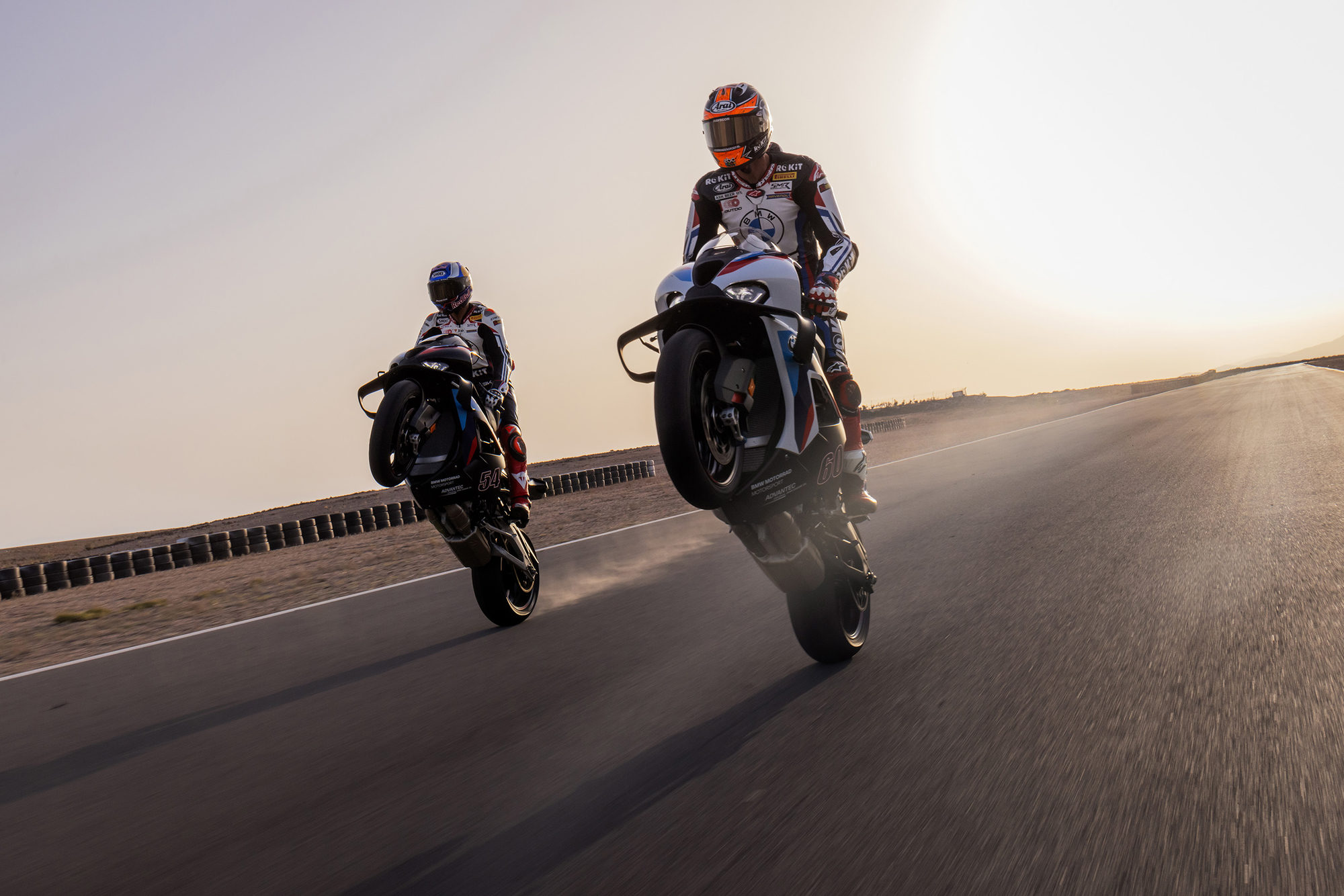 Two BMW M 1000 RR motorcycles riding side by side on a racetrack