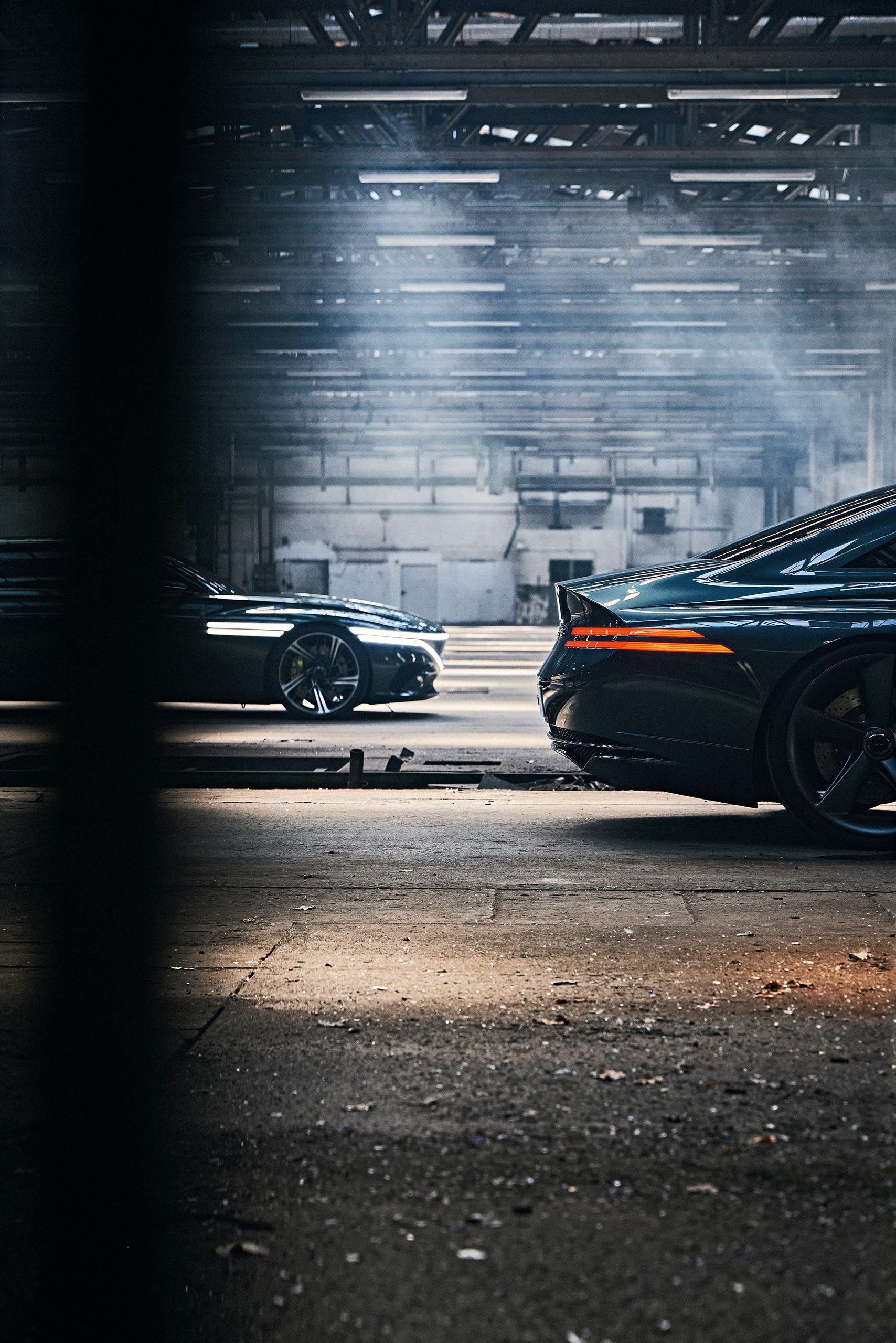 Side view of Genesis concept cars in a dark industrial setting