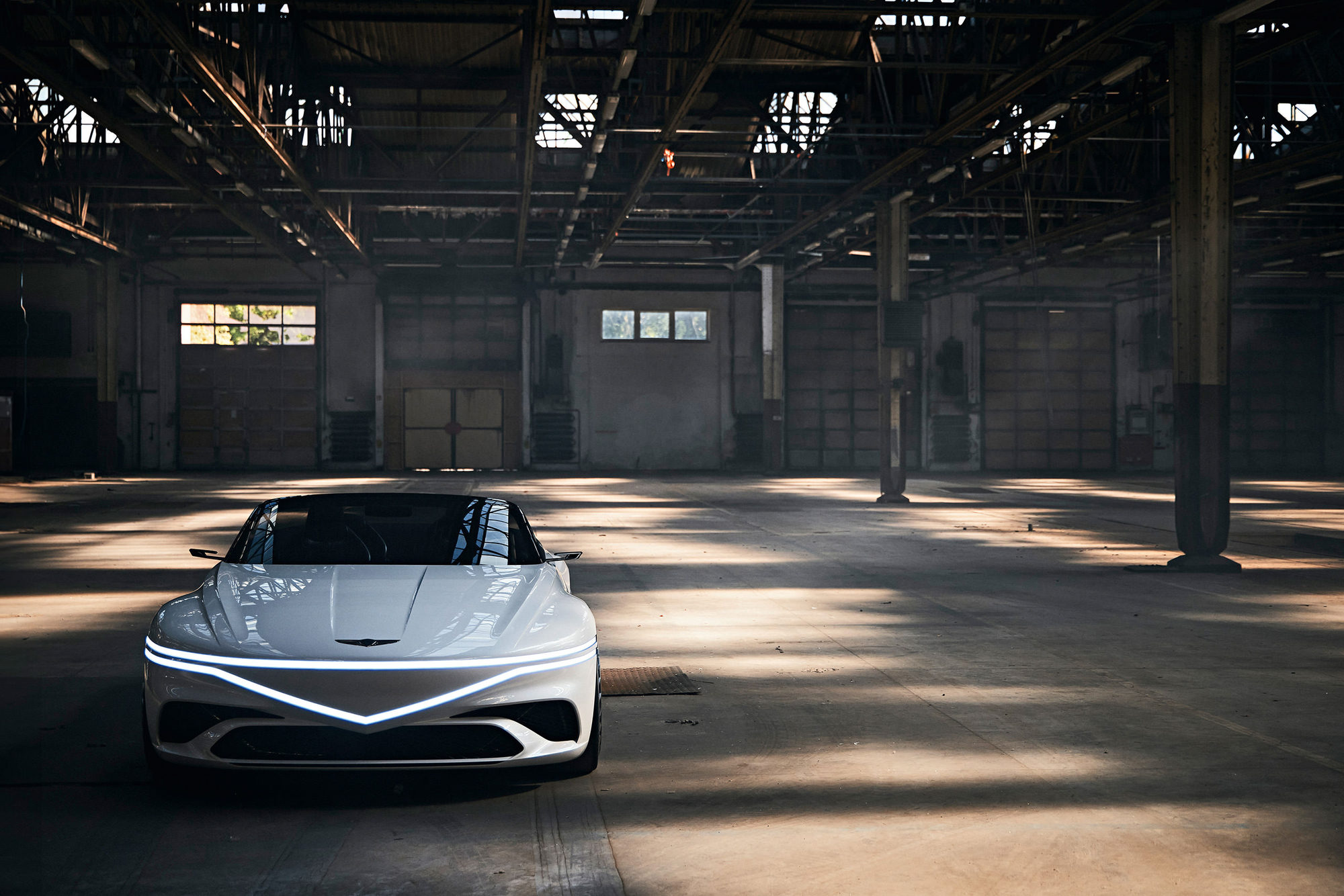 White Genesis concept car photographed in an industrial warehouse