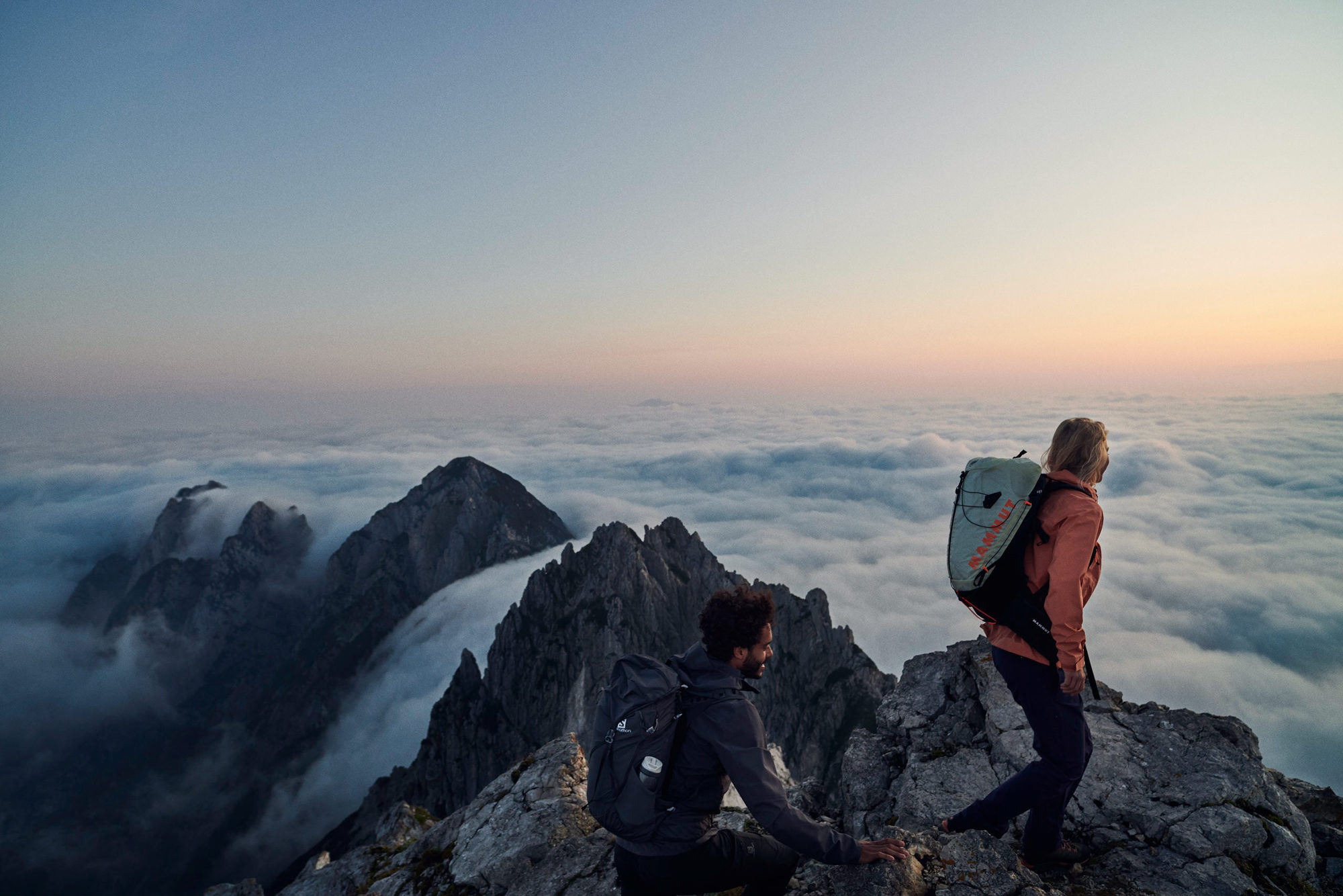 couple hiking on a mountain summit in Slovenia for INTERSPORT