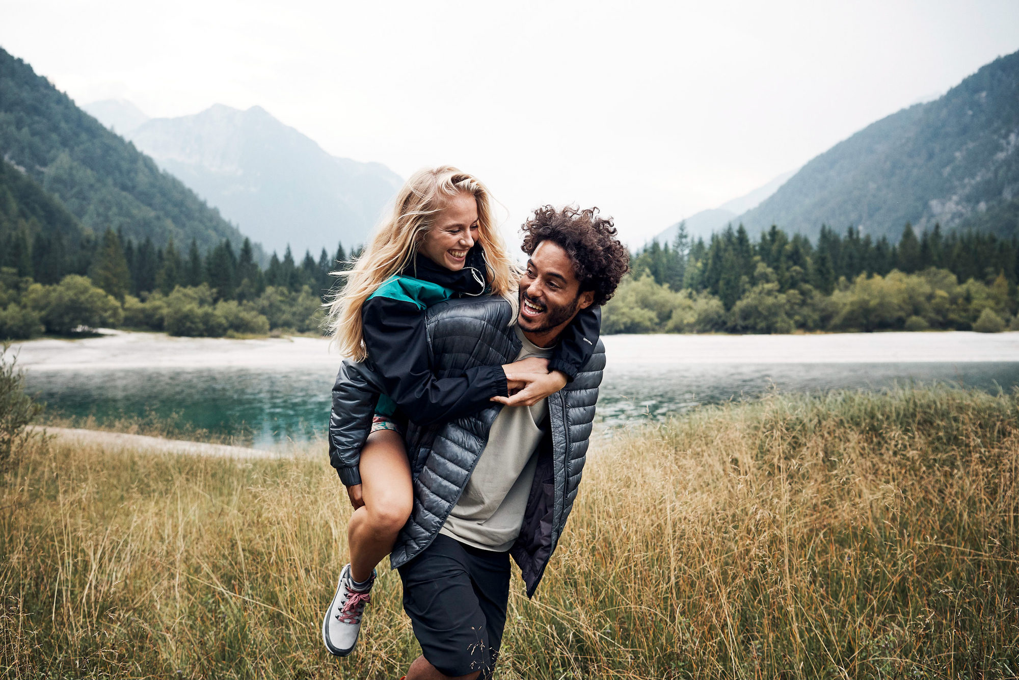 a man carrying his girl outdoors in the slovenian mountains for INTERSPORT