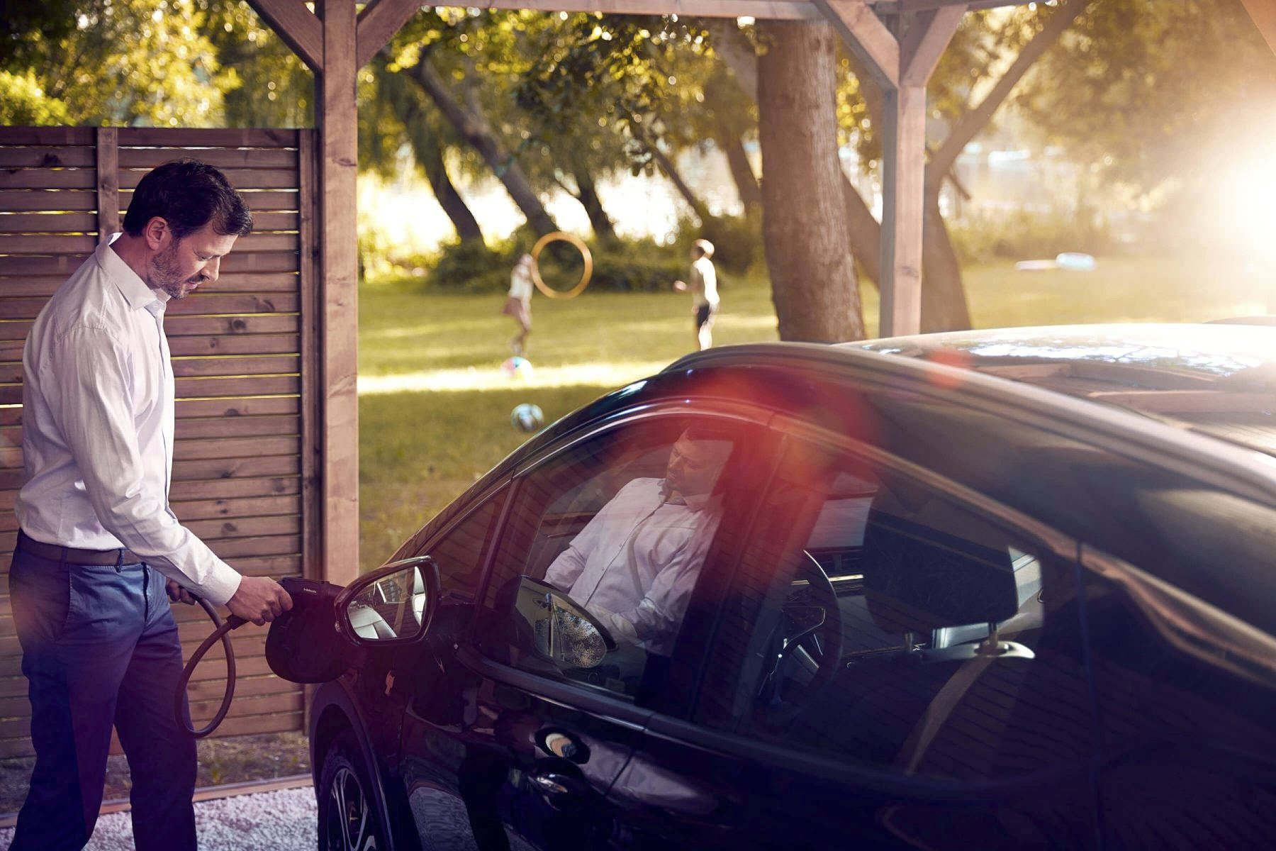 Electric car parked beneath trees during a Webasto eMobility campaign
