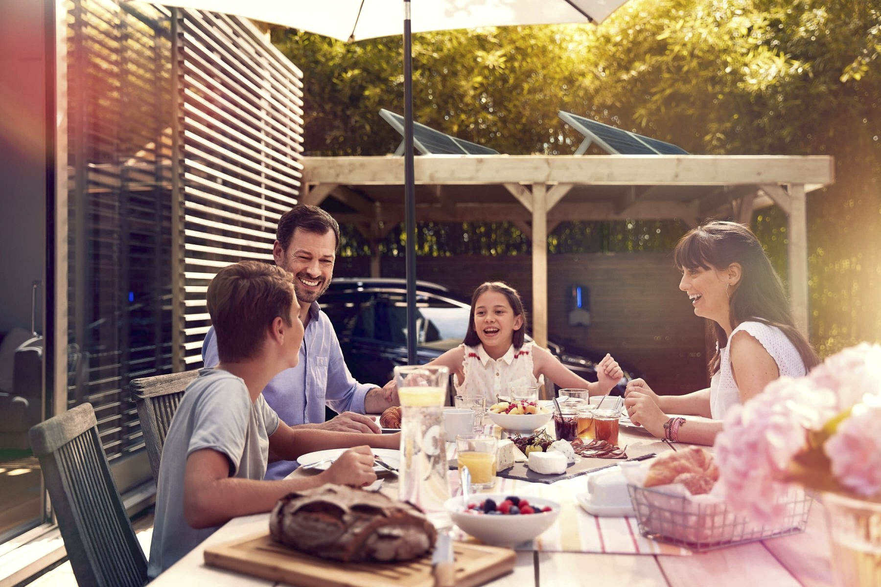 Family enjoying an outdoor meal at home during a Webasto eMobility campaign