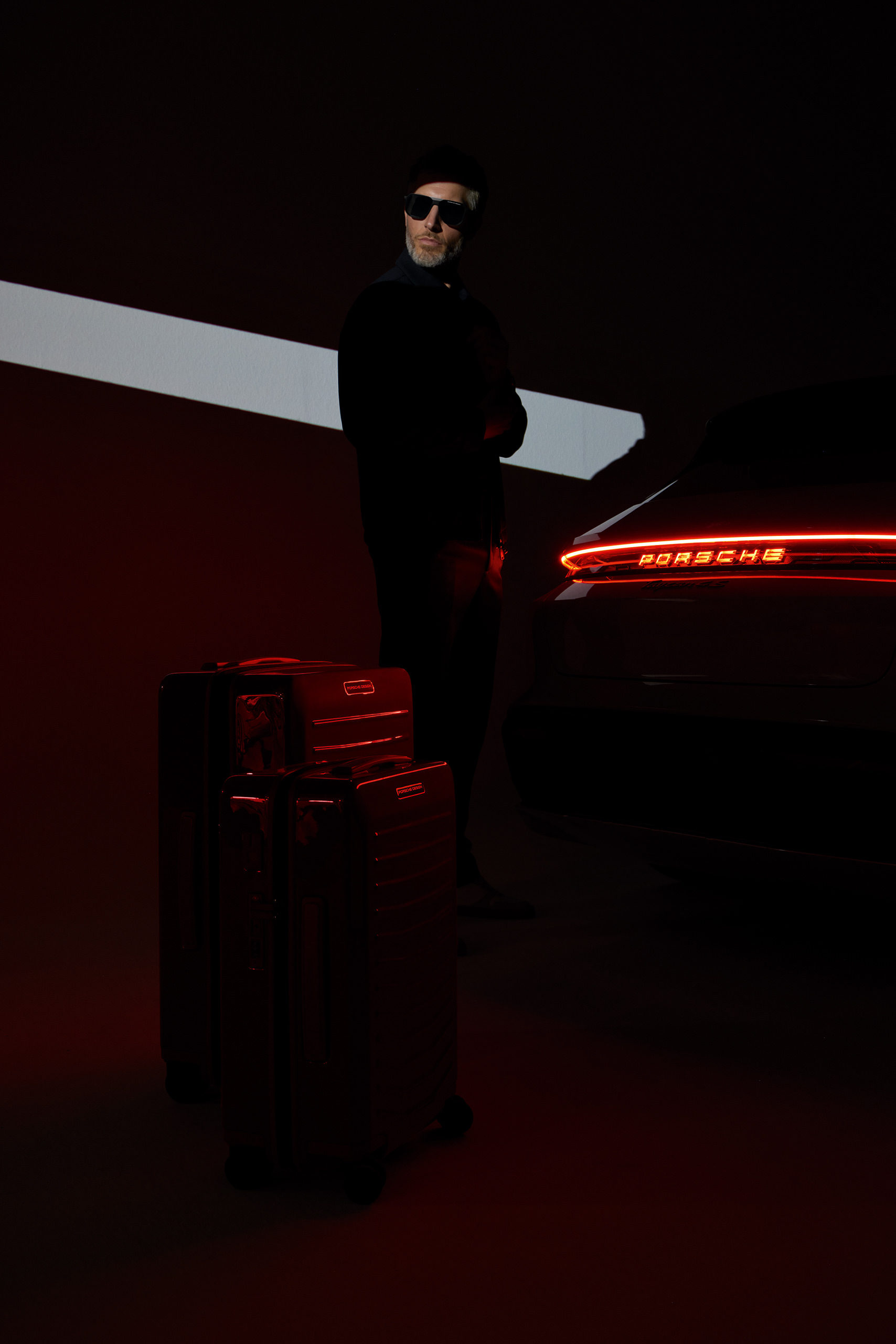 Male model in a dark studio setting with red lighting for Porsche Design